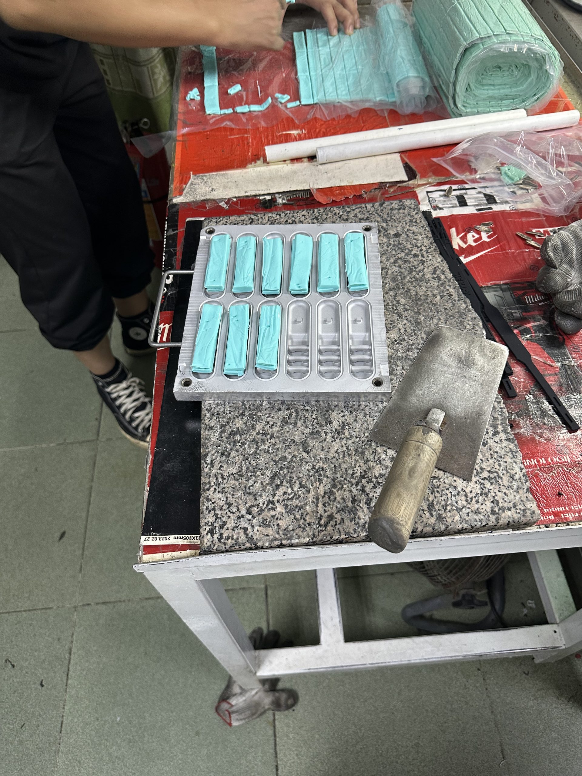 Prepared silicone material placed into custom mold cavities before curing