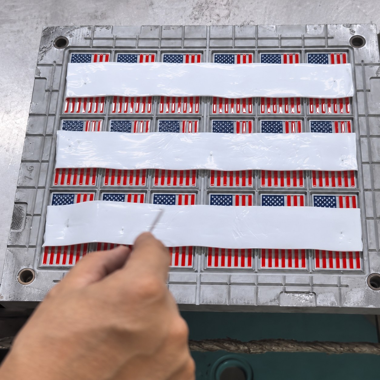 White silicone compound strips placed over the prepared mold.
